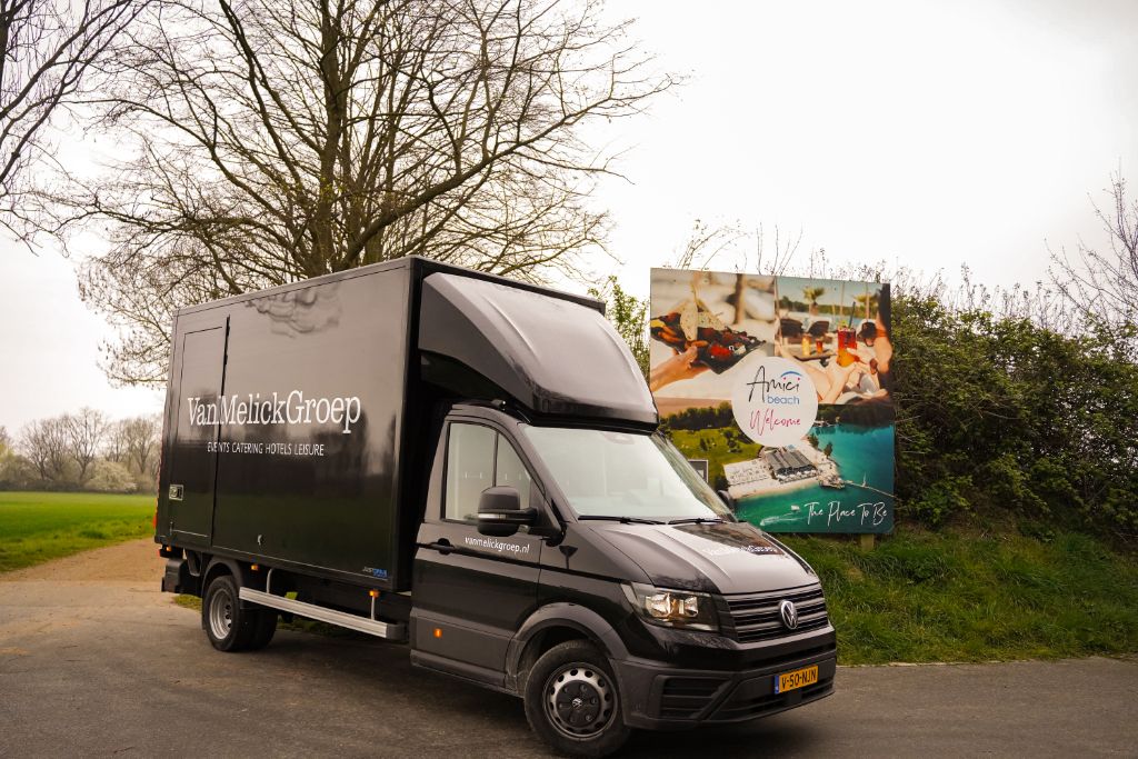 Van Melick Groep Fahrzeug vor dem Schild des Amici Beach Club in Wassenberg